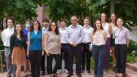 Well-dressed SIBDS program students stand outside smiling with a professor